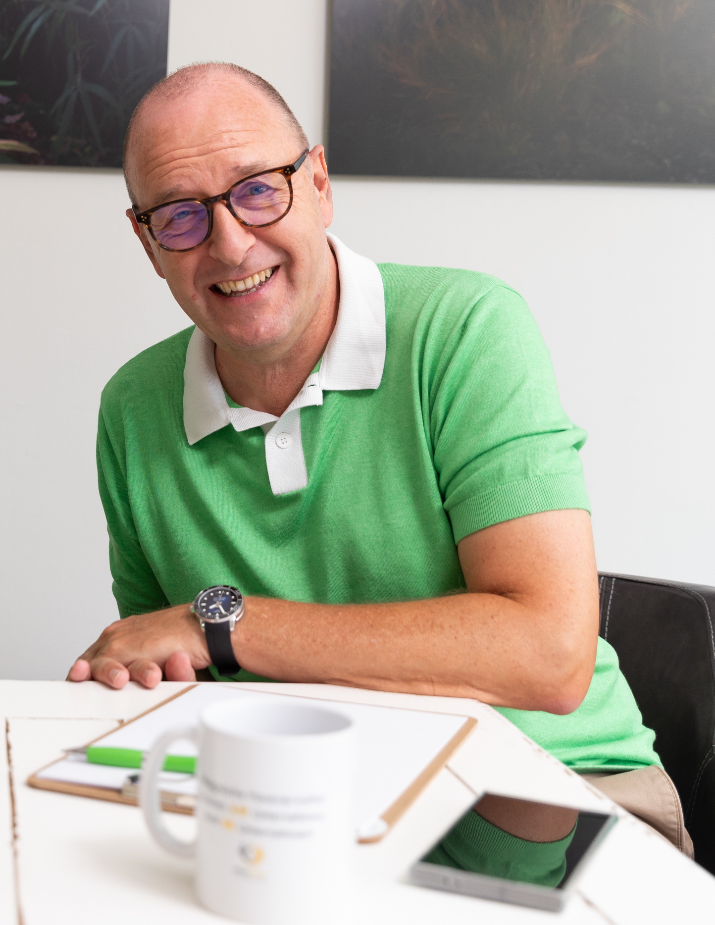 MF grün Michael Friedrich sitzt am Schreibtisch